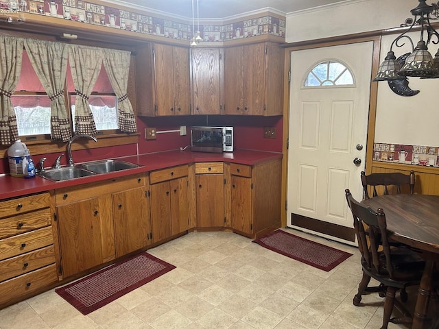 kitchen with crown molding, a healthy amount of sunlight, a sink, and light floors