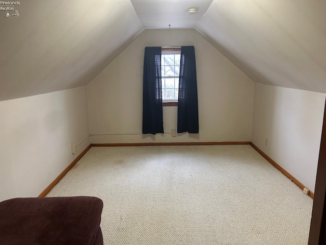 additional living space with lofted ceiling, baseboards, and carpet flooring