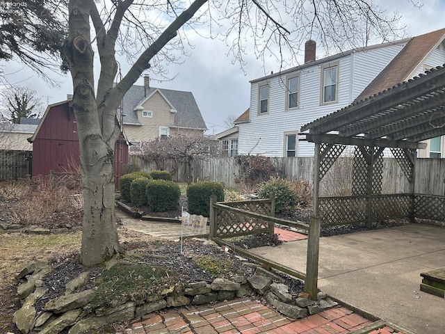 view of yard featuring an outbuilding, a patio area, a fenced backyard, and a pergola