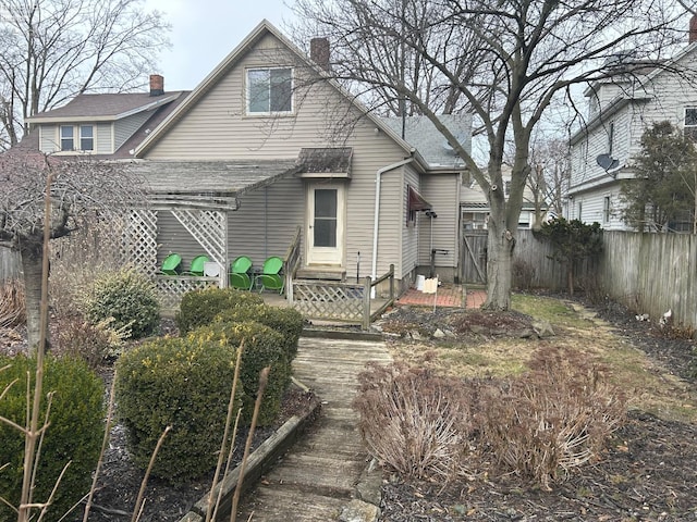 back of property with entry steps and fence