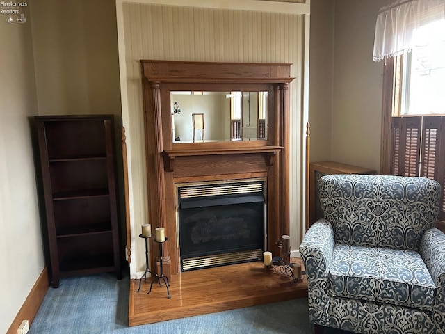 sitting room with carpet floors, a glass covered fireplace, and baseboards