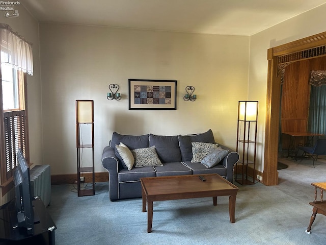 carpeted living area featuring baseboards and radiator