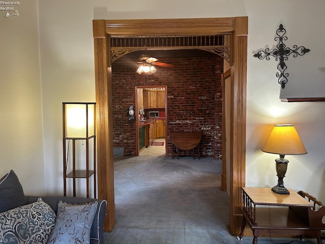 hall with carpet floors and brick wall