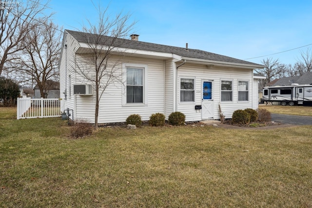 back of property featuring roof with shingles, a chimney, fence, and a yard