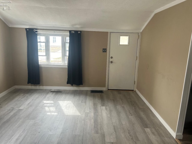 foyer featuring plenty of natural light, baseboards, and wood finished floors