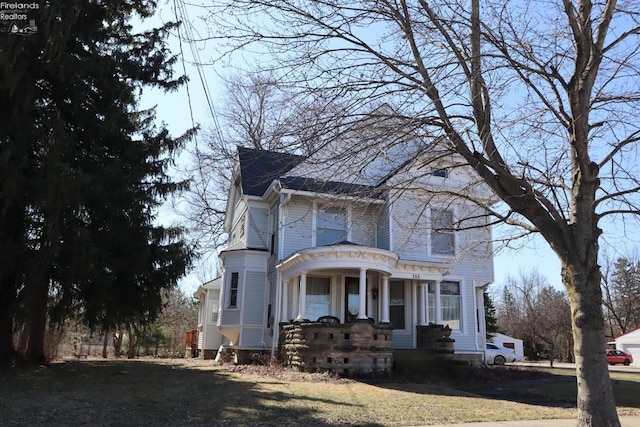 victorian home featuring covered porch and a front lawn