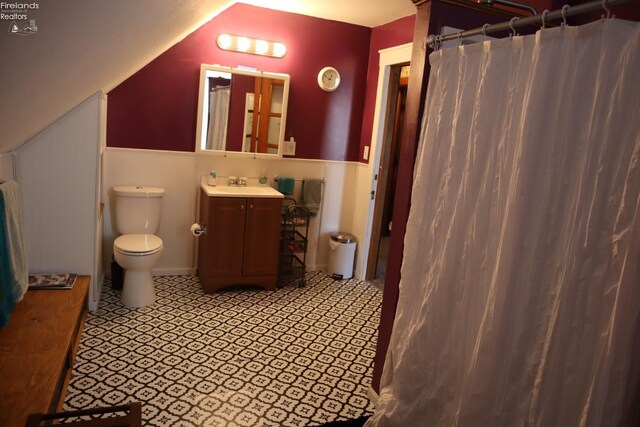 bathroom with a shower with curtain, toilet, vanity, and lofted ceiling