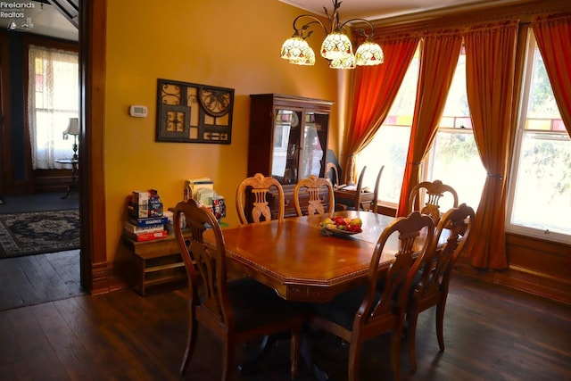 dining area with a notable chandelier and dark wood-type flooring