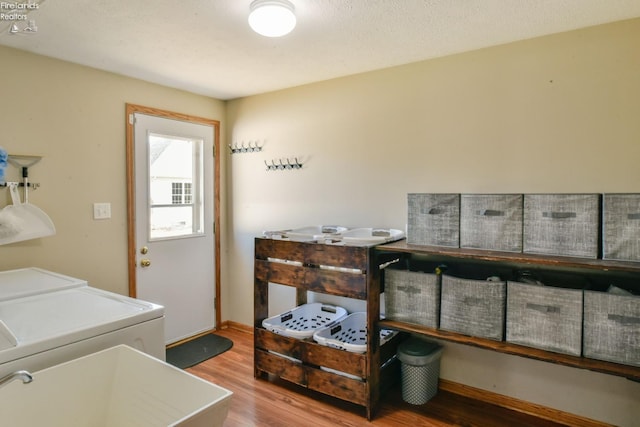 laundry area featuring laundry area, wood finished floors, independent washer and dryer, and baseboards