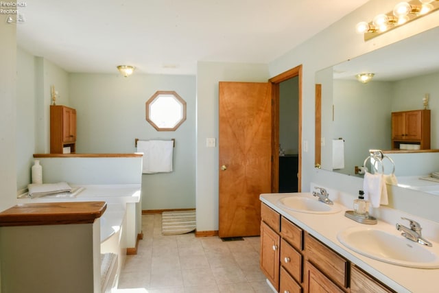 full bath featuring double vanity, a bathing tub, tile patterned flooring, and a sink