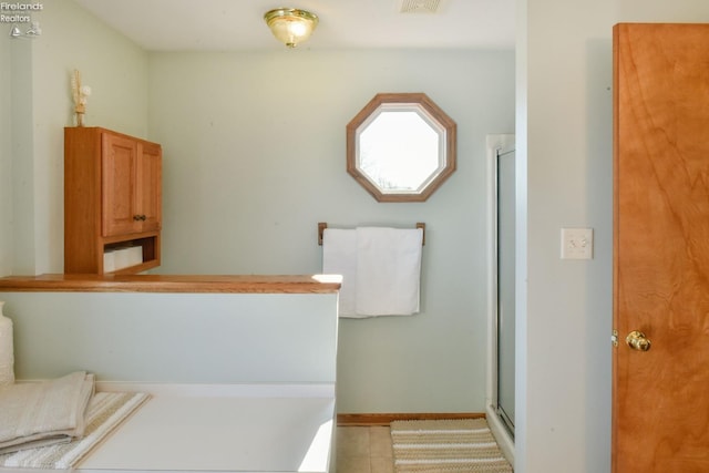 full bathroom with tile patterned floors, visible vents, a stall shower, and baseboards