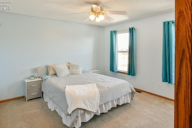 bedroom featuring light colored carpet, baseboards, and ceiling fan