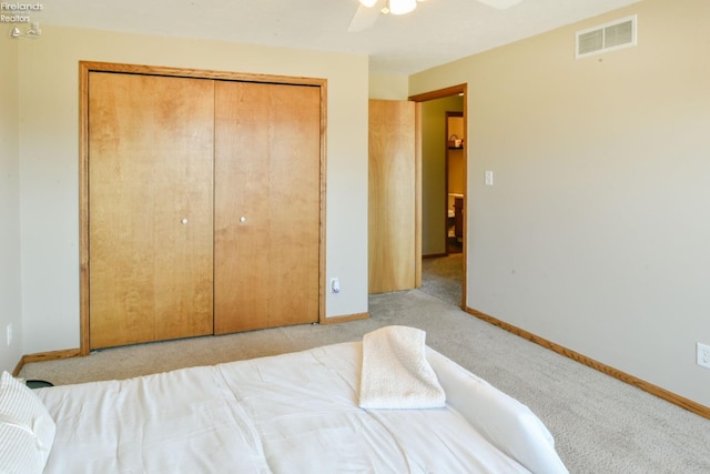 carpeted bedroom featuring visible vents, baseboards, and a closet