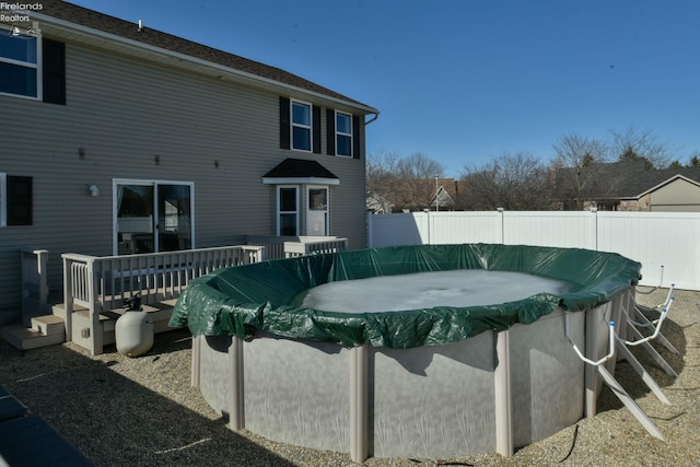 exterior space with a fenced in pool, a deck, and a fenced backyard