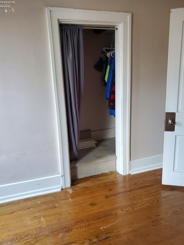 interior space featuring baseboards and wood finished floors