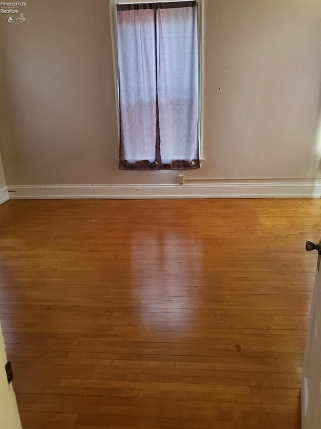 empty room featuring baseboards and wood finished floors