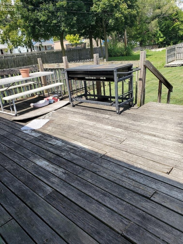 wooden terrace with a yard and fence