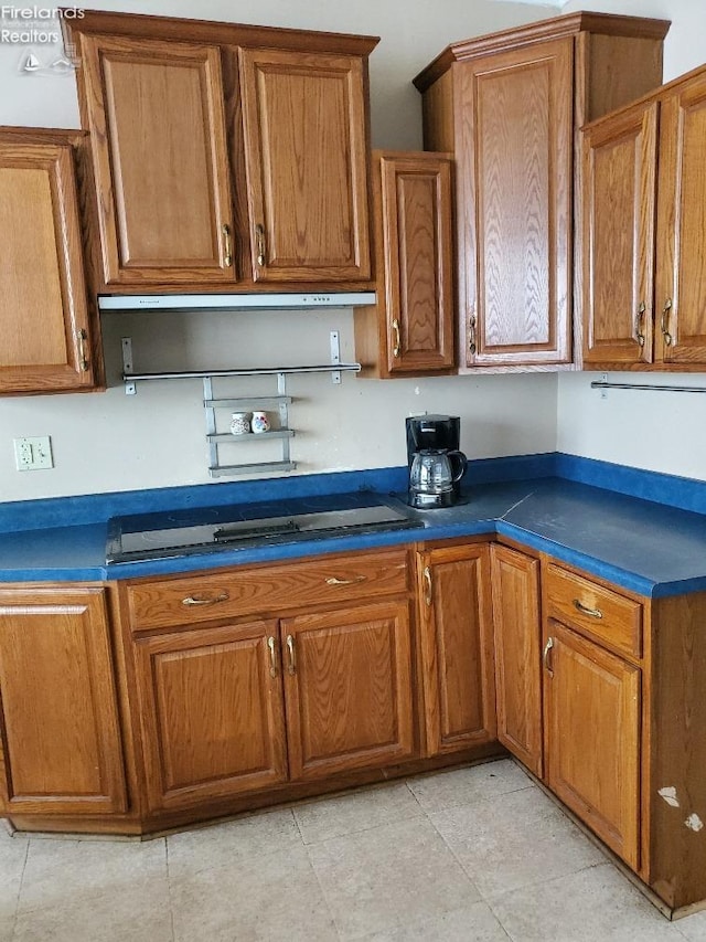 kitchen featuring brown cabinetry and dark countertops