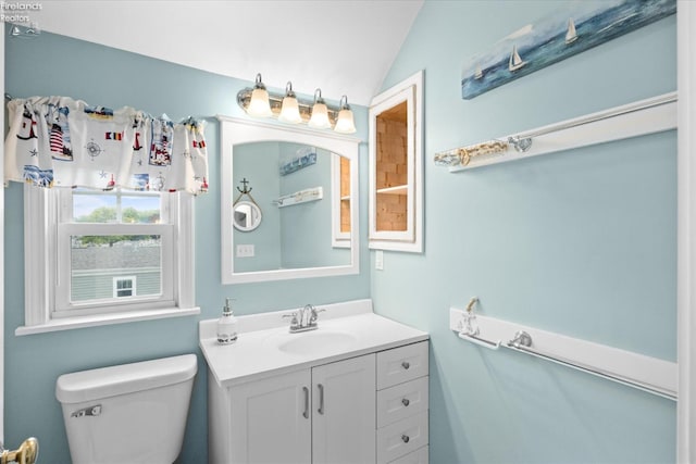 bathroom featuring toilet, vanity, and vaulted ceiling