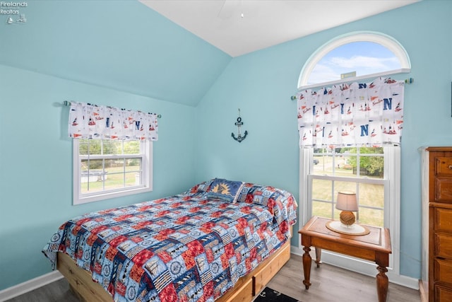 bedroom with ceiling fan, baseboards, wood finished floors, and vaulted ceiling