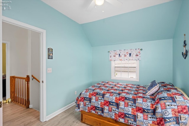 bedroom featuring lofted ceiling, wood finished floors, baseboards, and ceiling fan