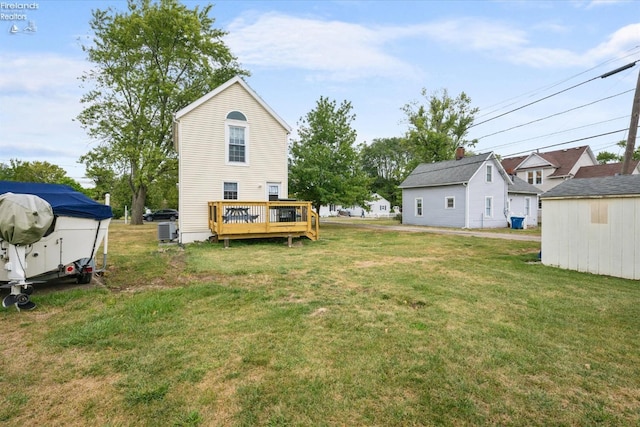 view of yard with central AC and a deck