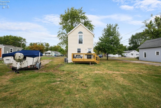 rear view of property with a lawn and a deck