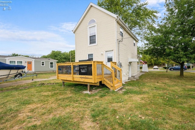 back of house featuring a deck and a yard