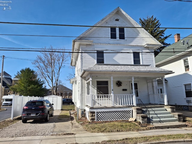 view of front of house featuring an outbuilding, a storage unit, covered porch, and driveway