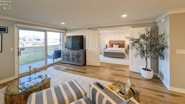 living room featuring baseboards, wood finished floors, visible vents, and ornamental molding