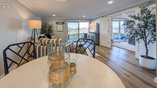 dining space with crown molding, recessed lighting, wood finished floors, and visible vents