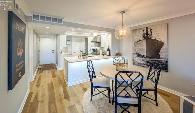 dining area with visible vents, light wood-style flooring, recessed lighting, crown molding, and baseboards