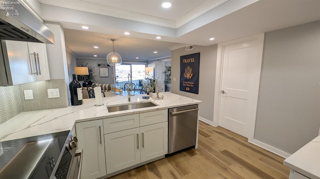 kitchen featuring a sink, stainless steel dishwasher, a peninsula, exhaust hood, and crown molding