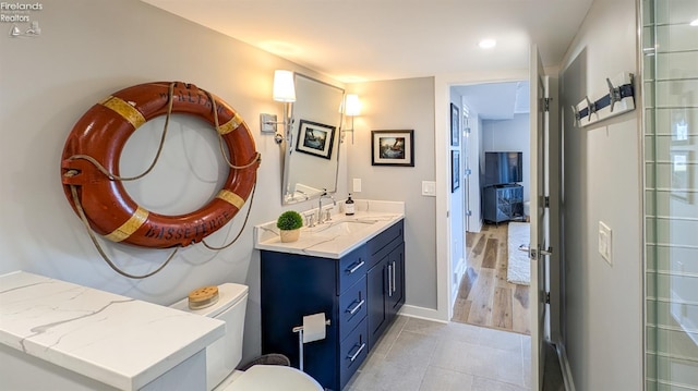 bathroom with tile patterned floors, baseboards, toilet, and vanity