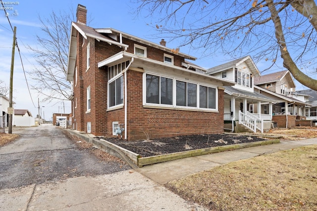 view of property exterior with brick siding and a chimney