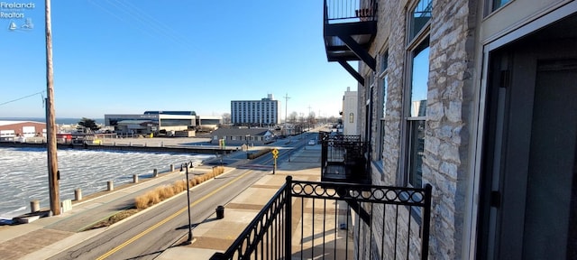 balcony featuring a city view and a water view