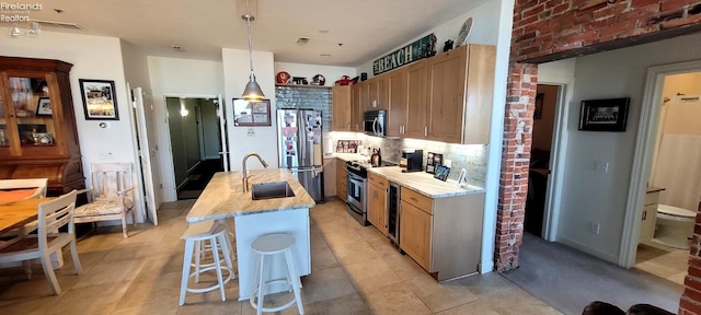 kitchen with a sink, decorative backsplash, wine cooler, appliances with stainless steel finishes, and pendant lighting