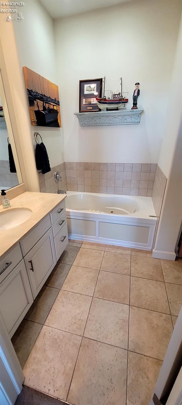 full bathroom with tile patterned flooring, vanity, and a garden tub