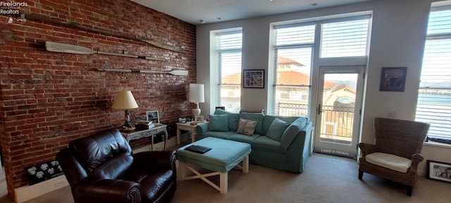 living room featuring carpet and brick wall