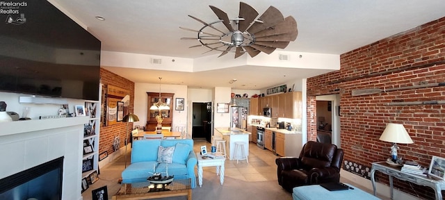 living area featuring visible vents, brick wall, and a fireplace