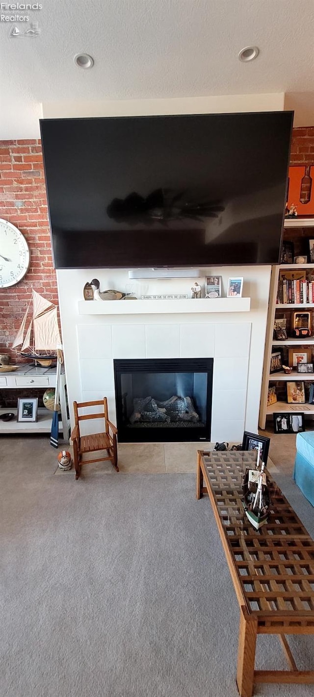 living room with a fireplace, carpet floors, and a textured ceiling