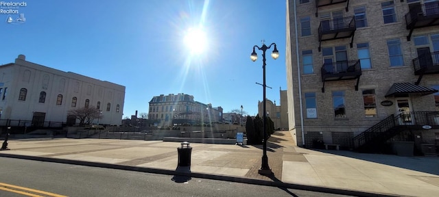 view of road with a city view, curbs, street lights, and sidewalks