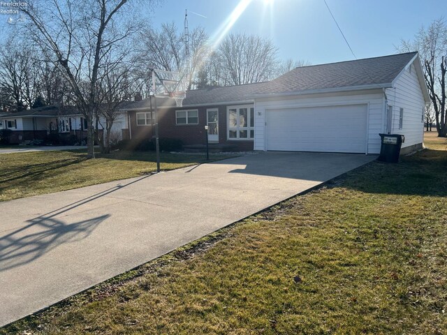 single story home featuring a front lawn, an attached garage, and concrete driveway