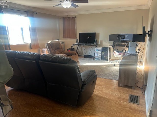 living area featuring visible vents, crown molding, a ceiling fan, and wood finished floors