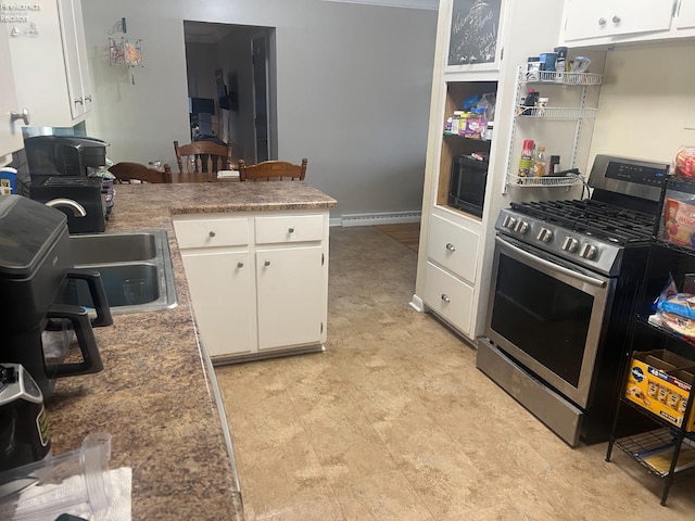 kitchen featuring a sink, a baseboard heating unit, white cabinets, black microwave, and stainless steel range with gas stovetop