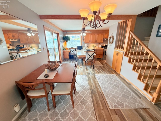 dining room featuring baseboards, stairs, beam ceiling, ceiling fan with notable chandelier, and light wood-style floors