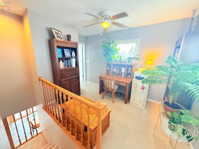 carpeted home office featuring baseboards and a ceiling fan