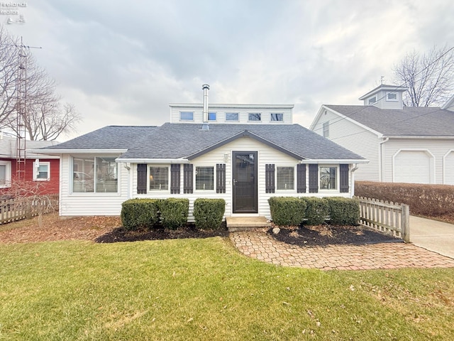 view of front of house with a front lawn, fence, and roof with shingles