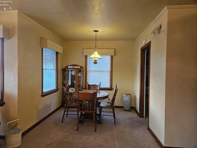 carpeted dining space featuring plenty of natural light, crown molding, and baseboards