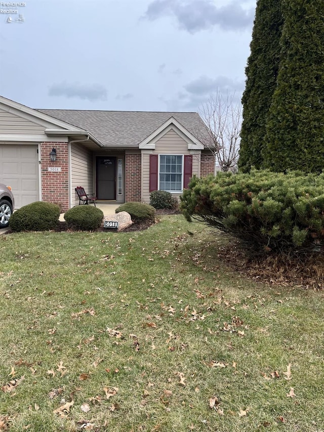 view of front of property featuring brick siding, an attached garage, a shingled roof, and a front lawn